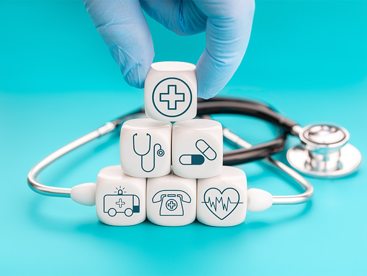 Healthcare symbols on wooden blocks beside a stethoscope representing healthcare access