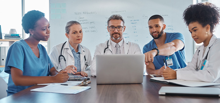 Doctor with healthcare colleagues reviewing clinical and tariff information